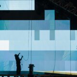 unrecognizable workman installing digital screen on stage