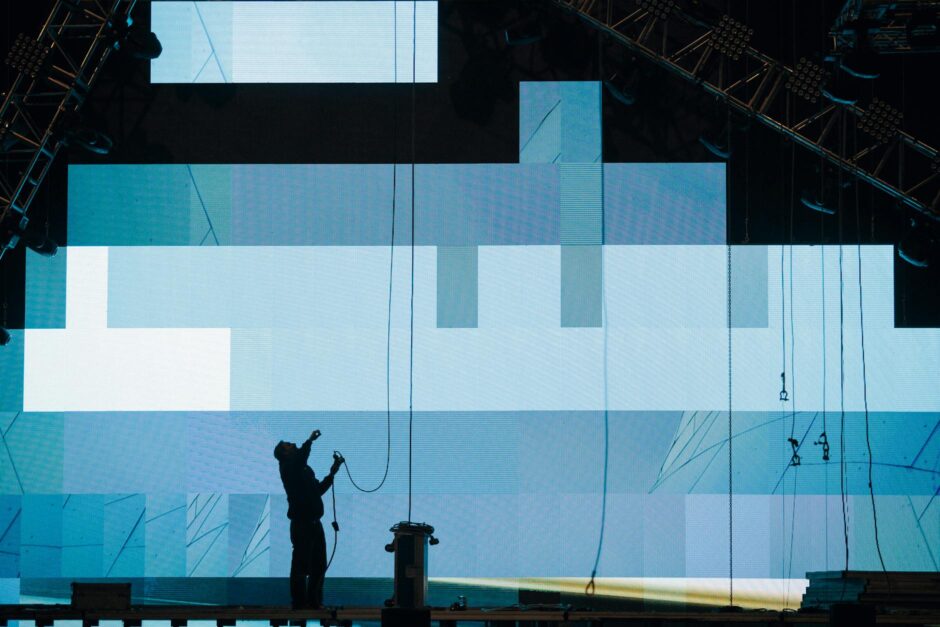 unrecognizable workman installing digital screen on stage